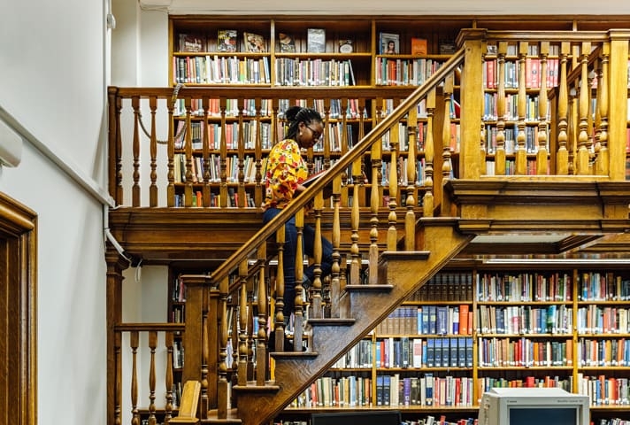student climbing stairs in British library