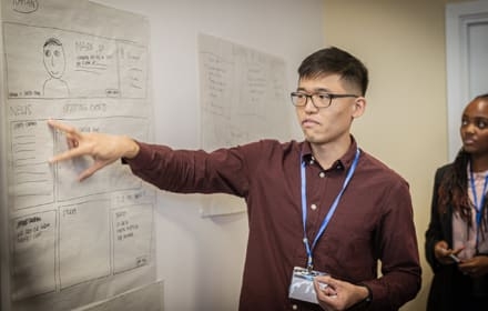 student pointing on whiteboard